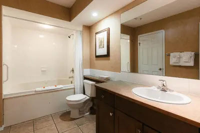 a bathroom with a sink and a toilet and a tub at Mountain View Resort and Suites at Fairmont Hot Springs in Fairmont Hot Springs