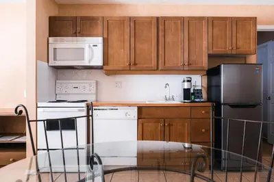 a kitchen with wooden cabinets and white appliances at Mountain View Resort and Suites at Fairmont Hot Springs in Fairmont Hot Springs