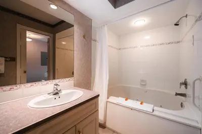 a bathroom with a sink and a bath tub at Mountain View Resort and Suites at Fairmont Hot Springs in Fairmont Hot Springs