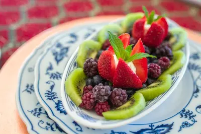 a bowl of fruit on a blue and white plate at Crystal's View Bed & Breakfast in North Vancouver