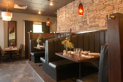 a restaurant with two tables and a brick wall at Hilltop Inn - Salmon Arm in Salmon Arm