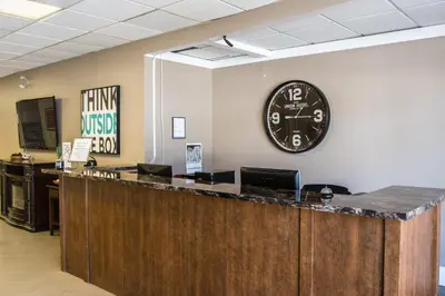 a large clock on the wall of a waiting room at Northwood Plaza Hotel in Prince George
