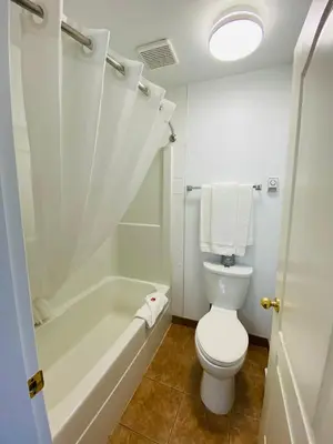 a bathroom with a toilet and a tub and a sink at Super 8 by Wyndham 100 Mile House in One Hundred Mile House