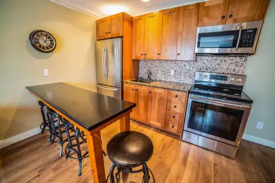 a kitchen with a table and a stove and a microwave at Prestige Hudson Bay Lodge & Conference Centre, WorldHotels Crafted Collection in Smithers