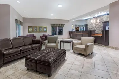 a waiting room with a couch and chairs and a table at Ramada by Wyndham Brooks in Brooks