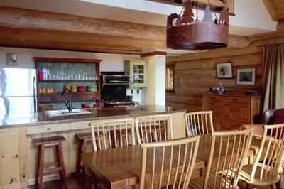 a kitchen with a table and chairs and a refrigerator at Snow Creek Cabins by Fernie Lodging Co in Fernie