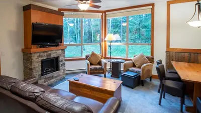 a living room with a leather couch and a fireplace at Timberline Lodges by Fernie Lodging Co in Fernie