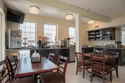 a kitchen and dining room with a table and chairs at Ramada Limited 100 Mile House in One Hundred Mile House