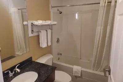 a bathroom with a shower and a toilet and a sink at Rodeway Inn & Suites in Kamloops