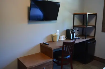 a desk with a chair and a tv on a wall at Sasquatch Inn in Harrison Mills