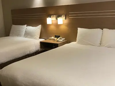 a hotel room with two beds and a telephone at Chalet Continental Motel in Valemount