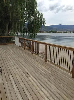 a wooden deck with a view of the water at Bella Villa Resort Motel in Osoyoos