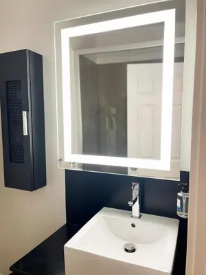 a bathroom with a white sink and a mirror at SKKY Hotel in Whitehorse