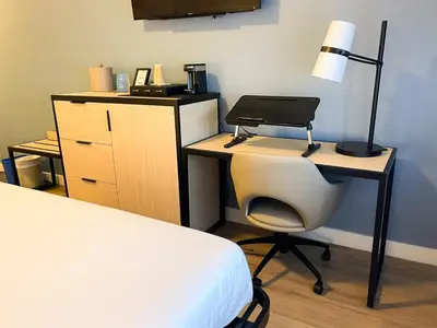 a bedroom with a desk with a laptop and a chair at SKKY Hotel in Whitehorse