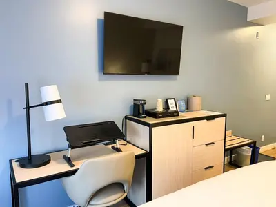 a bedroom with a desk with a laptop and a bed at SKKY Hotel in Whitehorse