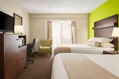 a hotel room with two beds and a television at Travelodge by Wyndham Lloydminster in Lloydminster