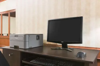 a computer monitor and a printer on a desk at Travelodge by Wyndham North Battleford in North Battleford