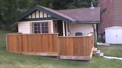a house with a wooden fence in the yard at Hillside Bungalows in Banff