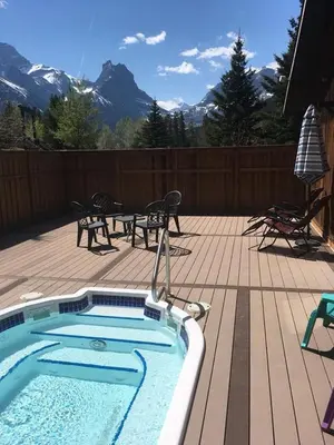 a swimming pool on a deck with a table and chairs at Banff Gate Mountain Resort in Canmore