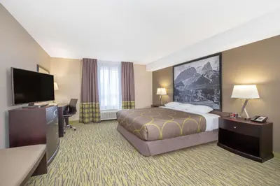 a hotel room with a bed and a flat screen tv at Super 8 by Wyndham Canmore in Canmore