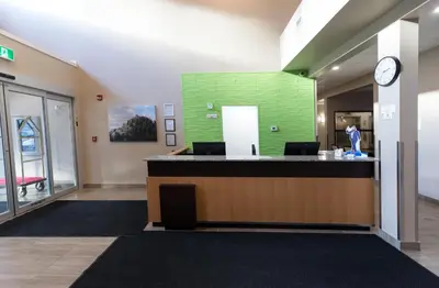 a lobby of a hospital with a green wall at Super 8 by Wyndham Canmore in Canmore