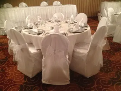 a table with white chairs and a white table cloth at Tropical Inn - North Battleford in North Battleford