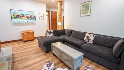 a living room with a couch and a table at Snow Creek Lodge by Fernie Lodging Co in Fernie