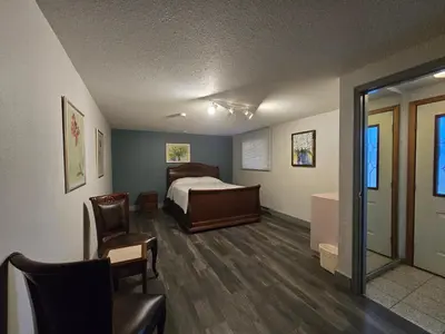 a bedroom with a bed and a table and a chair at Alpine Inn in Valemount