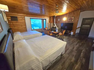 a bedroom with two beds and a living room at Alpine Inn in Valemount