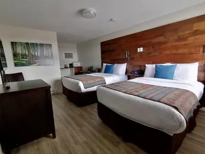 a hotel room with two beds and a desk at Snow Valley Lodging in Fernie