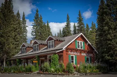 a wooden house with a sign in front of it at Paradise Lodge and Bungalows in Lake Louise