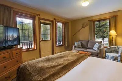 a bedroom with a bed and a tv and a couch at Paradise Lodge and Bungalows in Lake Louise