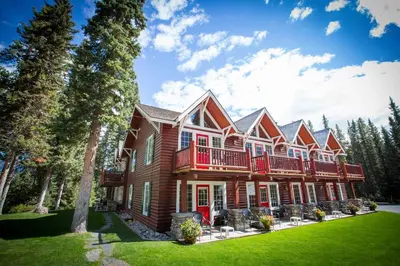 a large house with a yard and trees at Paradise Lodge and Bungalows in Lake Louise