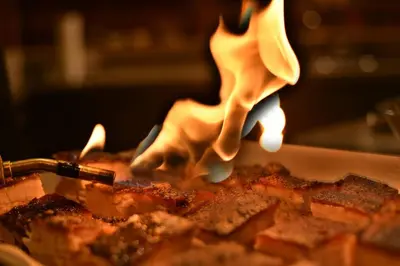 a person is cooking food in a pan at Inn on the Lake - Whitehorse in Marsh Lake