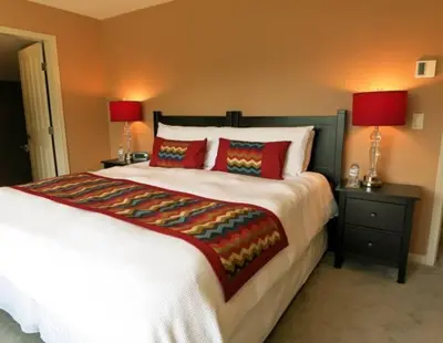 a bedroom with a large bed with two night stands and two lamps at A View of the Lake B & B in West Kelowna