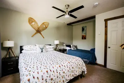 a bedroom with a bed and a ceiling fan at Alpenrose Revelstoke Bed & Breakfast in Revelstoke