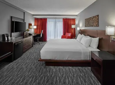 a hotel room with a bed and a desk and a television at Matrix Hotel in Edmonton
