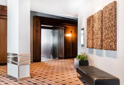 a lobby with a leather bench and a corridor at Matrix Hotel in Edmonton