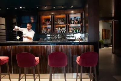 a man standing at a bar holding a wine glass at Matrix Hotel in Edmonton