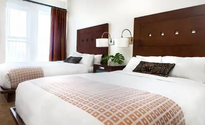 a hotel room with two beds and a window at Metterra Hotel on Whyte in Edmonton