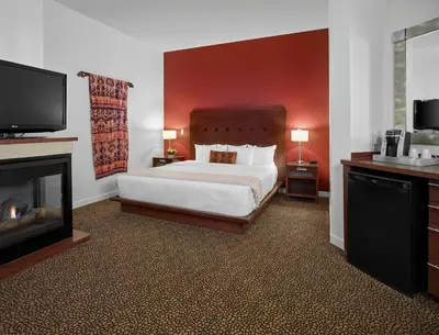 a bedroom with a bed and a flat screen tv at Metterra Hotel on Whyte in Edmonton