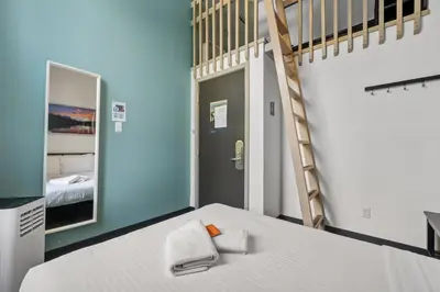a room with a bed with a ladder and a staircase at HI Lake Louise Alpine Centre - Hostel in Lake Louise