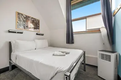 a small bedroom with a bed and a window at HI Lake Louise Alpine Centre - Hostel in Lake Louise