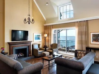 a living room with a fireplace and a tv at Oak Bay Beach Hotel in Victoria