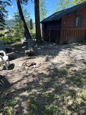 a fire pit next to a cabin with a fire place at Addison's Bungalows in Brisco