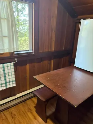 a wooden table in a room with a window at Addison's Bungalows in Brisco