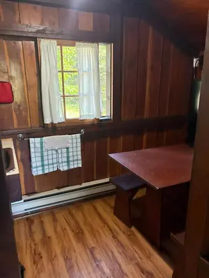 an empty room with a table and a window at Addison's Bungalows in Brisco