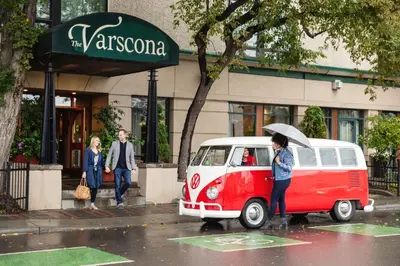 a woman holding an umbrella next to a red and white van at Varscona Hotel on Whyte in Edmonton