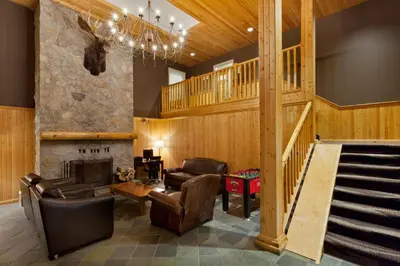 a living room with leather furniture and a staircase at Super 8 by Wyndham Valemount in Valemount