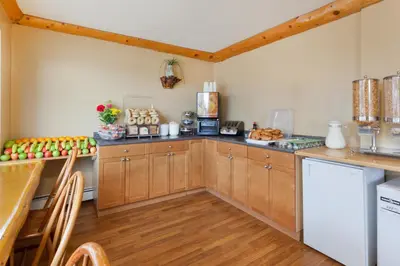 a kitchen with wooden cabinets and a counter top at Super 8 by Wyndham Valemount in Valemount